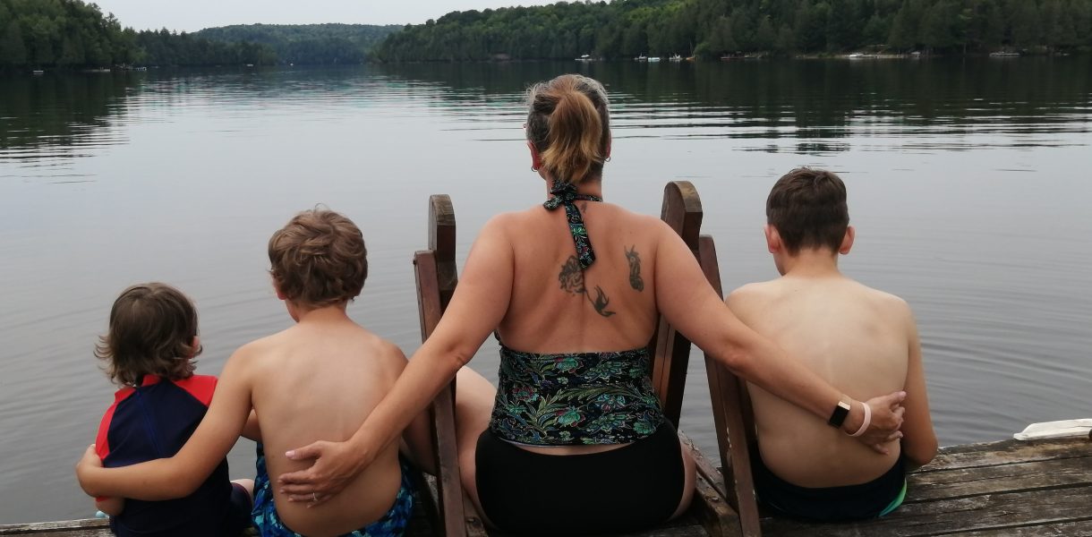 Mother and her boys, enjoying the view on a lake.
