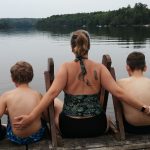 Mother and her boys, enjoying the view on a lake.