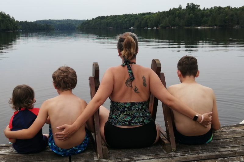 Mother and her boys, enjoying the view on a lake.